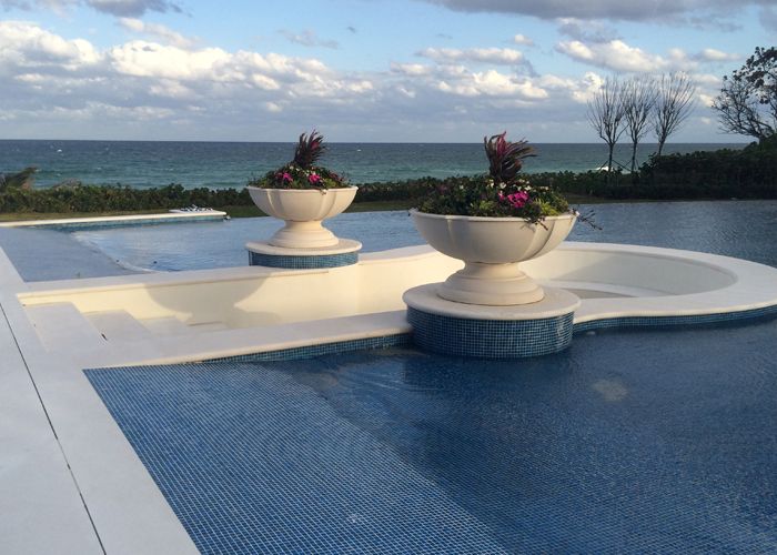 Cast stone planter urns on infinity pool edge with ocean view