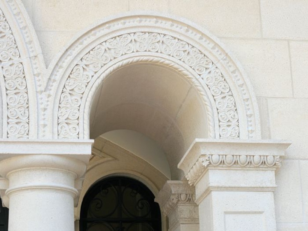 Ornately carved Romanesque stone arch and surround with floral relief detail