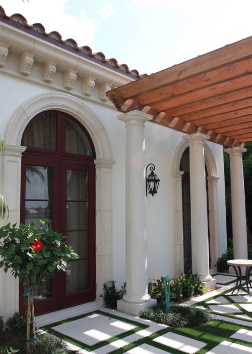 Cast stone arched doorway surround with columns and pergola on residential estate