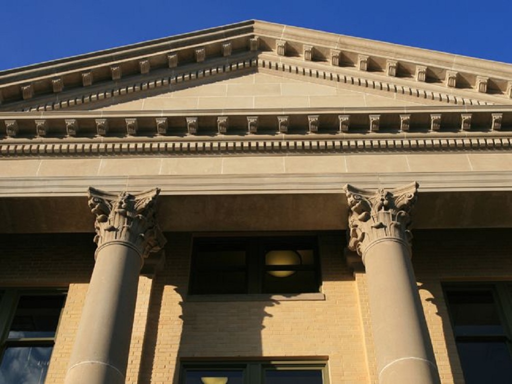 Classical stone building with Corinthian columns, pediment and ornate cornice
